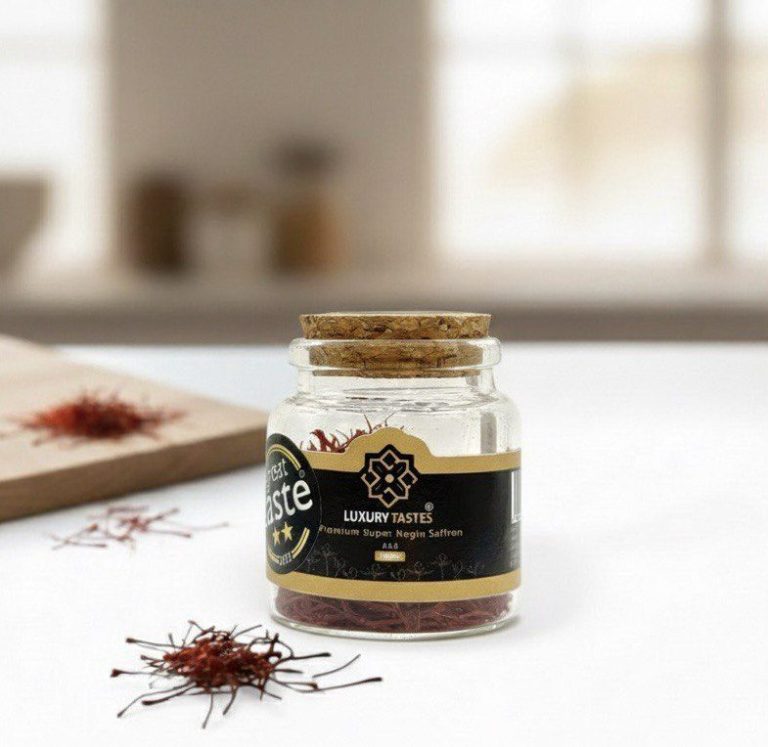 Glass jar of saffron with a wooden lid, surrounded by saffron threads on a countertop.