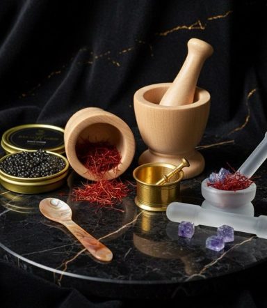 Various luxury spices and a mortar and pestle on a marble surface, alongside glass containers.